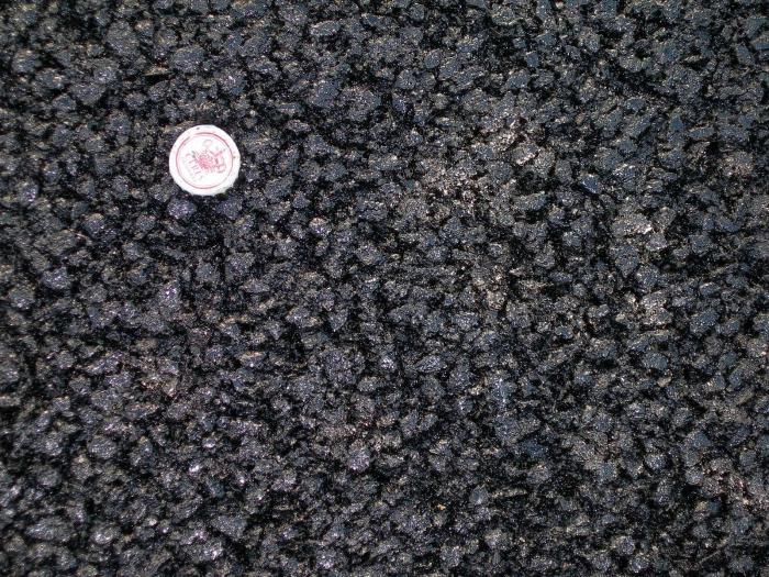 S.P.432 Antiskid come si presenta dopo la rullatura con sopra una tappo di birra come paragone con il pietrisco